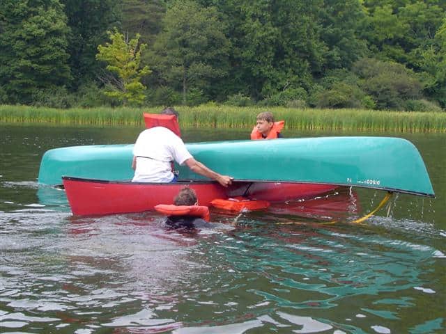 Upside-down canoe balanced on rescue boat