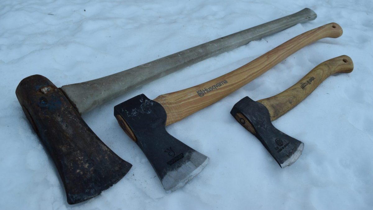 Perspective shot of Splitting Maul, Axe, and Hatchet lying in the snow