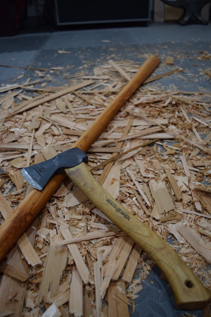 Hatchet used to carve Greenland Paddle, propped on that paddle in a pile of wood chips.