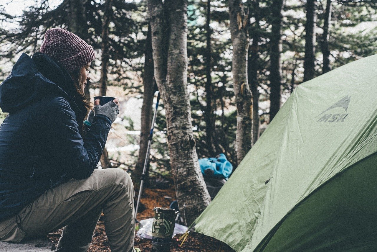 Woman sitting near tent in the morning